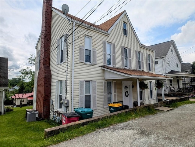 1003-1007 Youngstown Ridge Rd, Unity Twp, PA 15696 - view of front of home featuring a chimney, central AC unit, a front yard, and covered porch