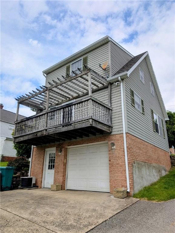 1003-1007 Youngstown Ridge Rd, Unity Twp, PA 15696 - view of home's exterior with an attached garage, brick siding, driveway, a wooden deck, and central AC