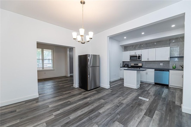 1044 Flemington St, Greenfield, PA 15217 - kitchen featuring appliances with stainless steel finishes, a chandelier, white cabinets, dark countertops, and dark wood-style floors