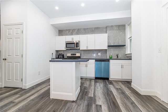 1044 Flemington St, Greenfield, PA 15217 - kitchen with appliances with stainless steel finishes, dark wood-style flooring, baseboards, white cabinetry, and backsplash