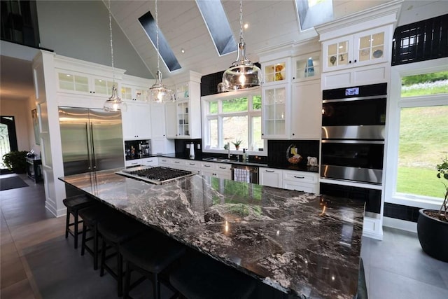 267 Reibold Rd, Forward Twp But, PA 16053 - kitchen featuring stainless steel appliances, white cabinets, pendant lighting, a large island, and high vaulted ceiling
