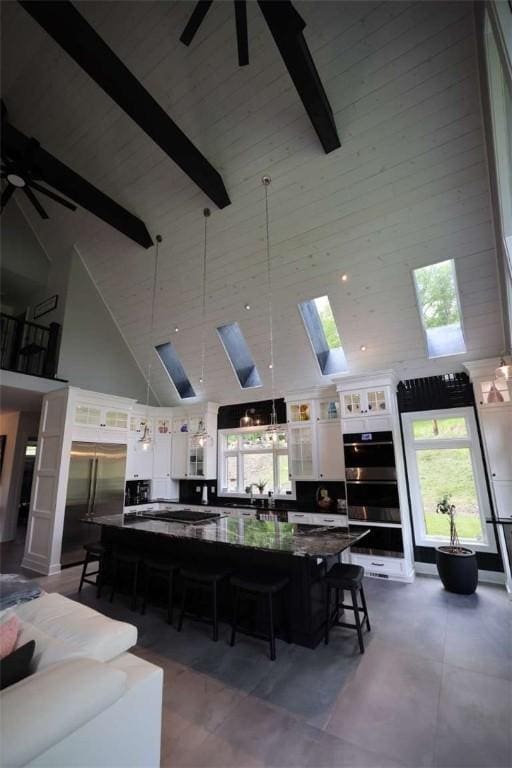 267 Reibold Rd, Forward Twp But, PA 16053 - living area with high vaulted ceiling, ceiling fan, beamed ceiling, plenty of natural light, and a skylight