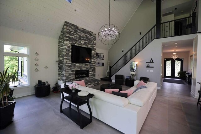 267 Reibold Rd, Forward Twp But, PA 16053 - living room featuring a chandelier, a stone fireplace, high vaulted ceiling, stairway, and baseboards