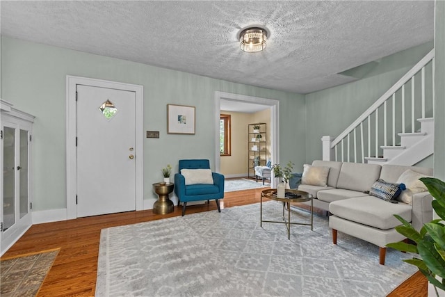 907 Greenfield Ave, Greenfield, PA 15217 - living room with wood finished floors, a textured ceiling, stairs, and baseboards
