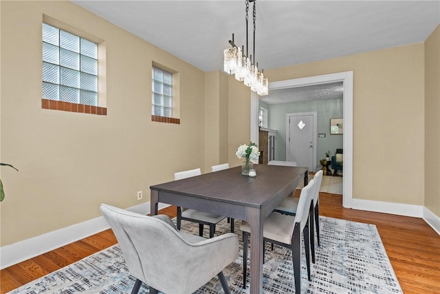 907 Greenfield Ave, Greenfield, PA 15217 - dining room featuring baseboards, wood finished floors, and a chandelier