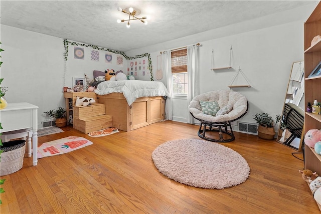 55 Evergreen Ter, Uniontown, PA 15401 - bedroom with wood finished floors, a textured ceiling, and a chandelier