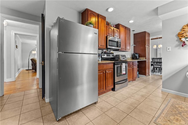 55 Evergreen Ter, Uniontown, PA 15401 - kitchen featuring appliances with stainless steel finishes, light tile patterned floors, light countertops, recessed lighting, and brown cabinetry