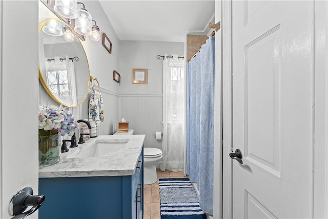 55 Evergreen Ter, Uniontown, PA 15401 - full bath featuring vanity, toilet, healthy amount of natural light, tile patterned flooring, and a wainscoted wall
