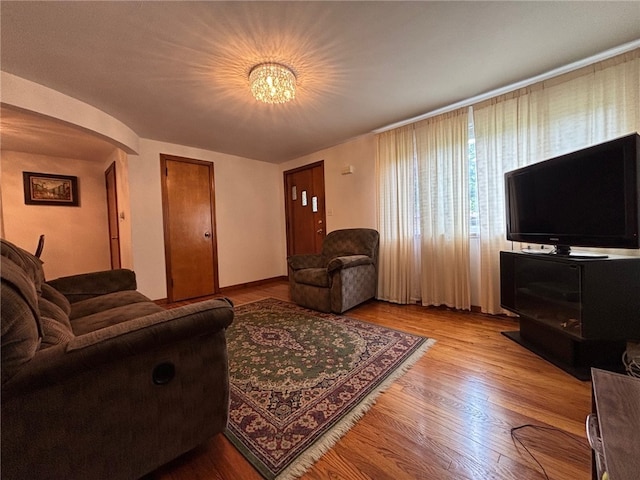1132 Onondago St, Squirrel Hill, PA 15218 - living room with light wood-type flooring, arched walkways, and a chandelier
