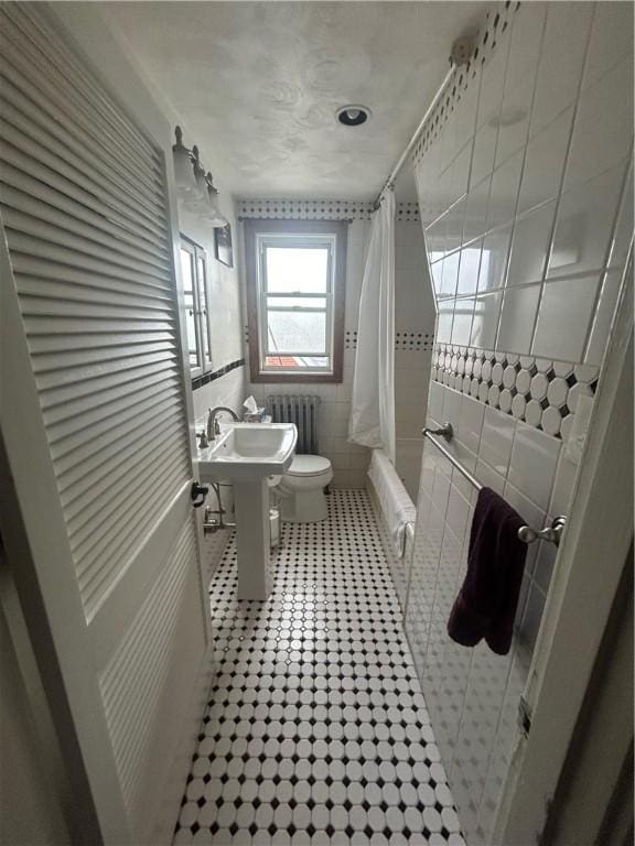 4735 Stanton Ave, Stanton Heights, PA 15201 - full bathroom featuring radiator, toilet, shower / bath combo with shower curtain, tile walls, and tile patterned flooring