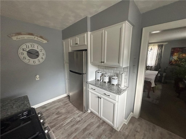 4735 Stanton Ave, Stanton Heights, PA 15201 - kitchen featuring stainless steel appliances, light wood-style flooring, white cabinetry, and decorative backsplash