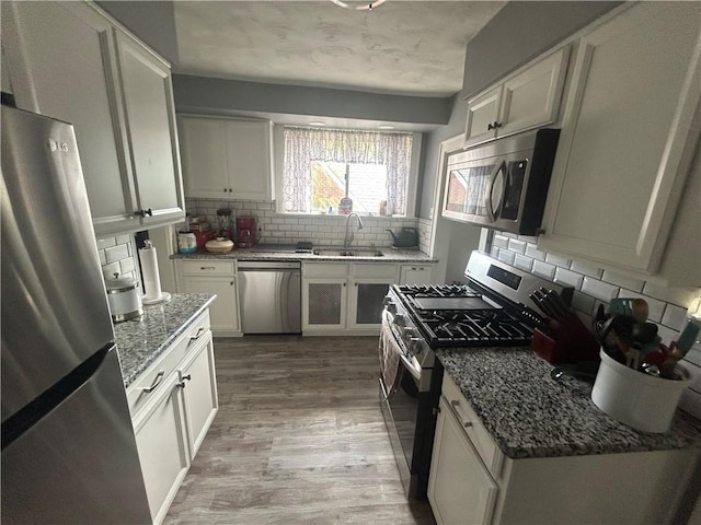 4735 Stanton Ave, Stanton Heights, PA 15201 - kitchen with stainless steel appliances, a sink, backsplash, light wood finished floors, and stone countertops