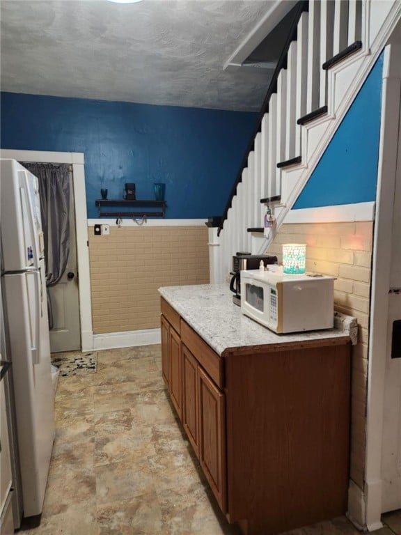 534 Broadway St, Masontown, PA 15461 - kitchen featuring white appliances, brown cabinetry, and a wainscoted wall