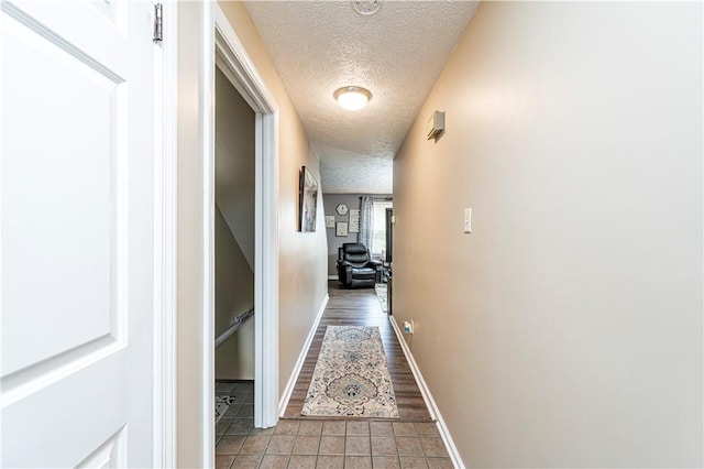 101 Canyon Ct, Unity Twp, PA 15650 - corridor featuring a textured ceiling, baseboards, and light tile patterned floors