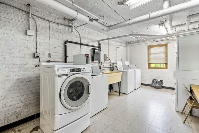 144 N Dithridge St Unit 703, Oakland, PA 15213 - community laundry featuring separate washer and dryer, brick wall, and light floors