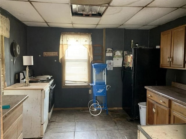 1649 Iselin Rd, Conemaugh/Young Twps Ind, PA 15681 - kitchen with a drop ceiling, brown cabinetry, range, freestanding refrigerator, and light tile patterned floors