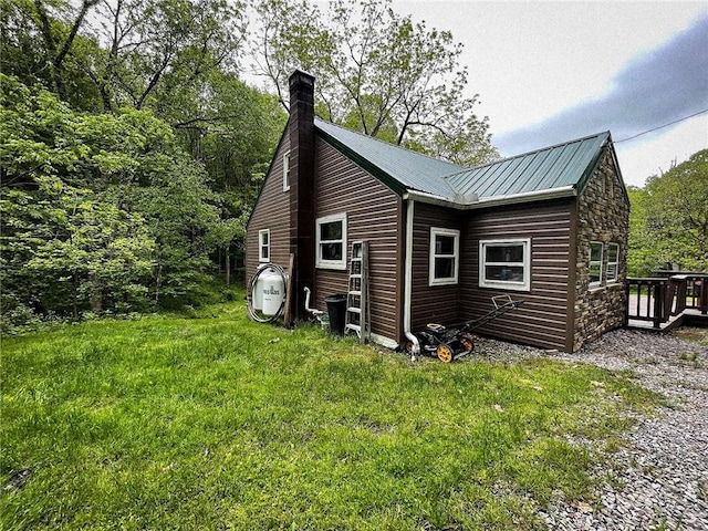 141 Minich Rd, Center Twp But, PA 16001 - view of home's exterior featuring a chimney, metal roof, stone siding, a yard, and a deck