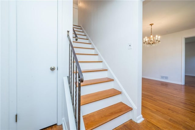 2443 Rose Garden Rd, Banksville/Westwood, PA 15220 - stairway with a chandelier, wood finished floors, and baseboards