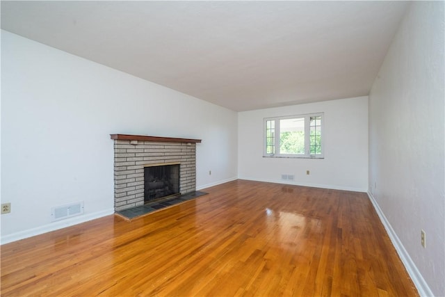 2443 Rose Garden Rd, Banksville/Westwood, PA 15220 - unfurnished living room featuring a brick fireplace, wood finished floors, and baseboards