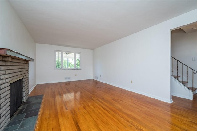 2443 Rose Garden Rd, Banksville/Westwood, PA 15220 - unfurnished living room featuring stairs, a fireplace, wood finished floors, and baseboards