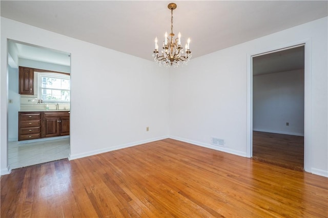 2443 Rose Garden Rd, Banksville/Westwood, PA 15220 - unfurnished room with a sink, a chandelier, light wood-style floors, and baseboards