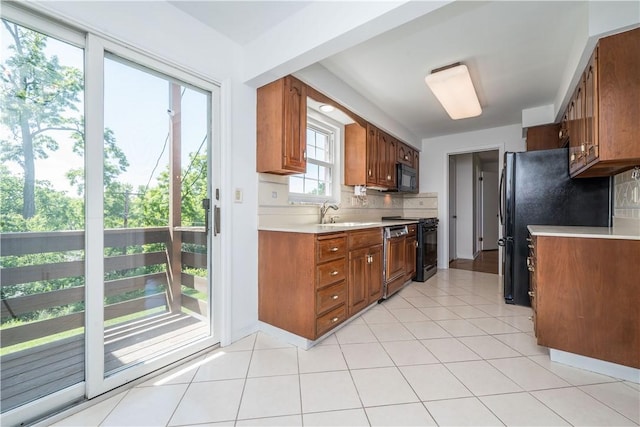 2443 Rose Garden Rd, Banksville/Westwood, PA 15220 - kitchen featuring black appliances, light countertops, tasteful backsplash, brown cabinetry, and light tile patterned flooring
