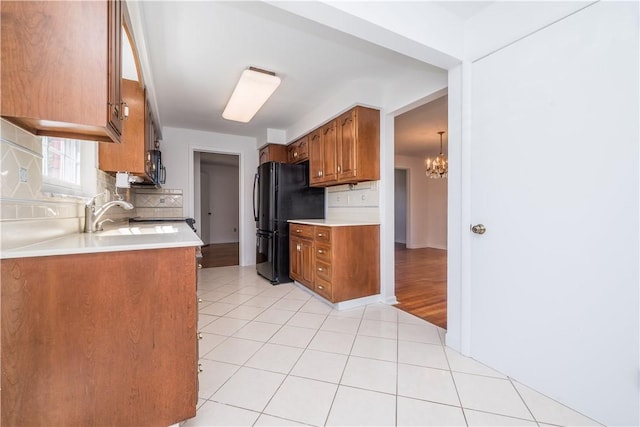 2443 Rose Garden Rd, Banksville/Westwood, PA 15220 - kitchen with black appliances, a sink, brown cabinets, backsplash, and a chandelier