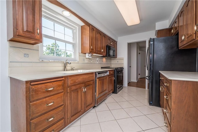 2443 Rose Garden Rd, Banksville/Westwood, PA 15220 - kitchen with black appliances, a sink, tasteful backsplash, light countertops, and brown cabinetry
