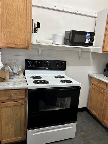 1015 Gerritt St, Homewood-Brushton, PA 15208 - kitchen featuring electric range oven, black microwave, light countertops, and brown cabinetry