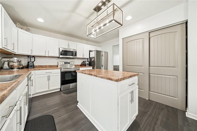 11572 Salerno Dr, North Huntingdon, PA 15642 - kitchen with appliances with stainless steel finishes, a center island, dark wood finished floors, white cabinets, and recessed lighting