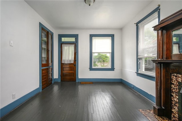 920 Roup Ave, Brackenridge, PA 15014 - unfurnished living room featuring baseboards, plenty of natural light, and dark wood-type flooring