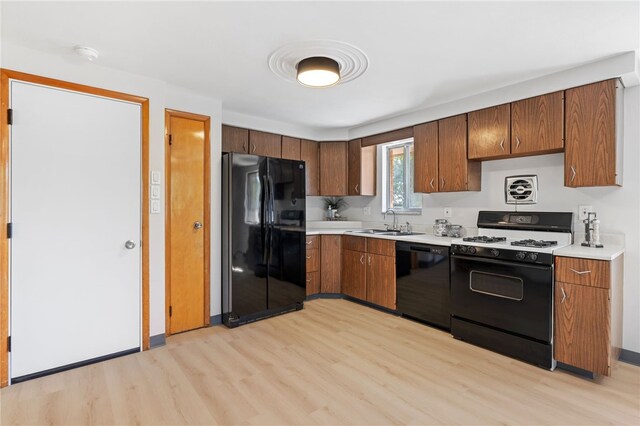 1317 Cathell Rd, Baldwin Boro, PA 15236 - kitchen featuring black appliances, light wood-style flooring, light countertops, and brown cabinetry