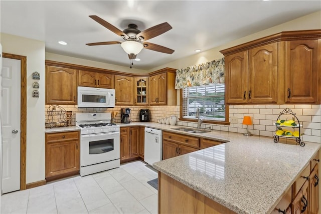108 Covington Dr, Center Twp, PA 16001 - kitchen featuring white appliances, a sink, brown cabinetry, a peninsula, and light stone counters