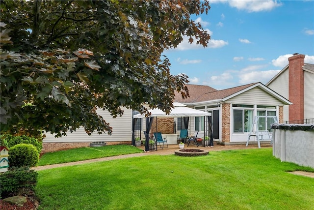 108 Covington Dr, Center Twp, PA 16001 - rear view of house with a fire pit, a yard, and a sunroom
