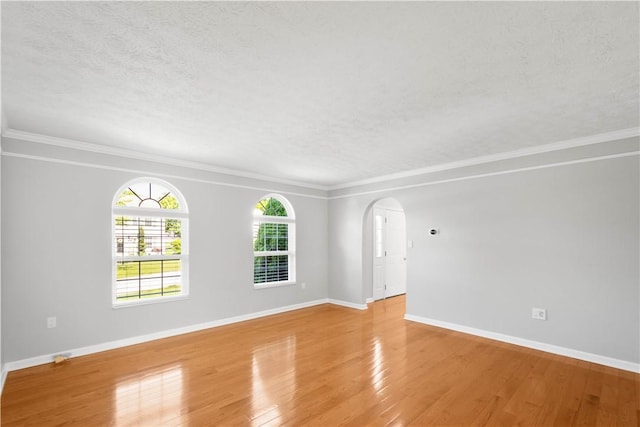 821 Kingston Dr, South Fayette, PA 15057 - unfurnished room featuring arched walkways, light wood-style floors, a textured ceiling, baseboards, and crown molding