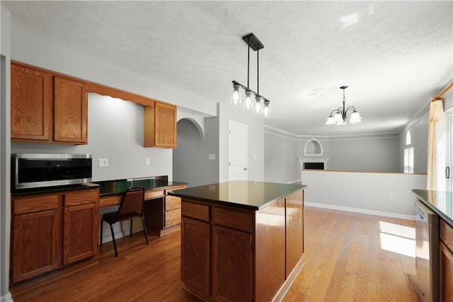 821 Kingston Dr, South Fayette, PA 15057 - kitchen with stainless steel appliances, dark countertops, a textured ceiling, arched walkways, and light wood-type flooring