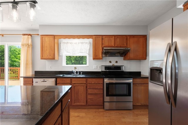 821 Kingston Dr, South Fayette, PA 15057 - kitchen featuring stainless steel appliances, under cabinet range hood, light wood-style floors, a sink, and brown cabinetry