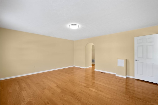 821 Kingston Dr, South Fayette, PA 15057 - empty room with arched walkways, light wood-style flooring, and baseboards