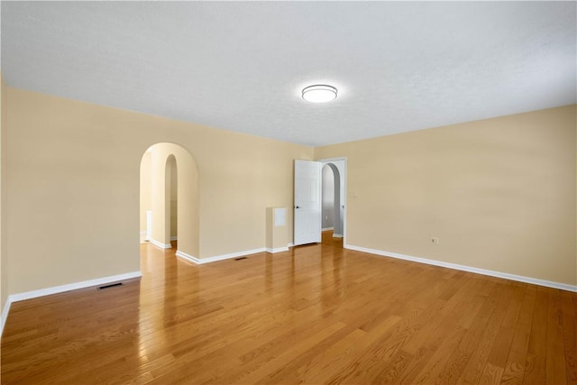 821 Kingston Dr, South Fayette, PA 15057 - unfurnished room featuring arched walkways, light wood-style floors, and baseboards