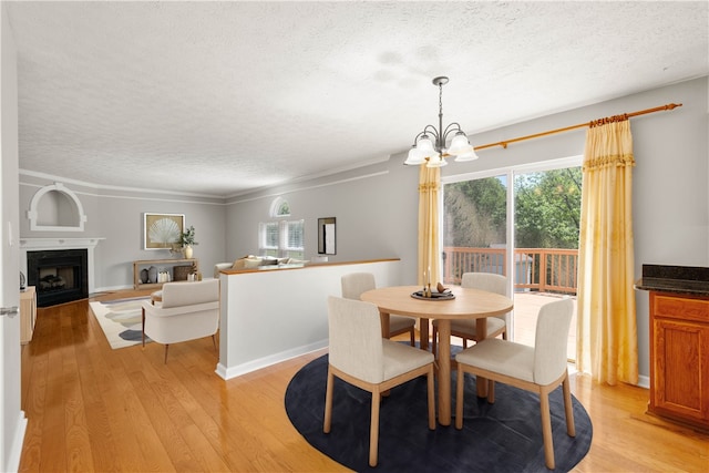 821 Kingston Dr, South Fayette, PA 15057 - dining area featuring a textured ceiling, a chandelier, light wood finished floors, a fireplace, and crown molding