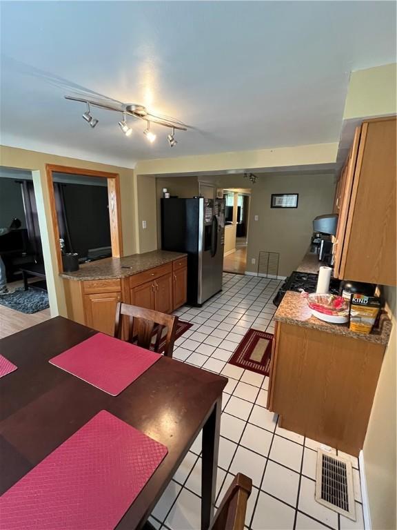 417 Longview Dr, Monroeville, PA 15146 - kitchen featuring stainless steel fridge, light tile patterned floors, brown cabinets, and dark countertops