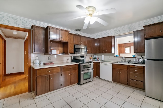 1007 High St, Luzerne Twp, PA 15417 - kitchen with appliances with stainless steel finishes, light countertops, a sink, ceiling fan, and wallpapered walls