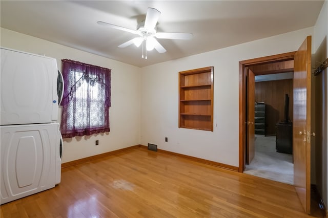 1007 High St, Luzerne Twp, PA 15417 - unfurnished bedroom with stacked washing machine and dryer, baseboards, light wood-style flooring, and ceiling fan