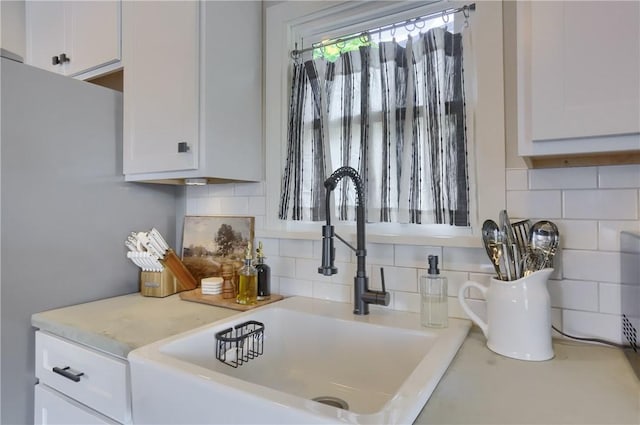27 Laurel Ave, City Of Washington, PA 15301 - kitchen view of white cabinets, light countertops, a sink, tasteful backsplash, and freestanding refrigerator