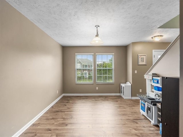 8045 Maureen Dr, Cranberry Twp, PA 16066 - unfurnished dining area featuring light wood finished floors, baseboards, and a textured ceiling