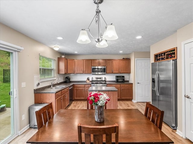 8045 Maureen Dr, Cranberry Twp, PA 16066 - kitchen featuring stainless steel appliances, dark countertops, a sink, a center island, and backsplash