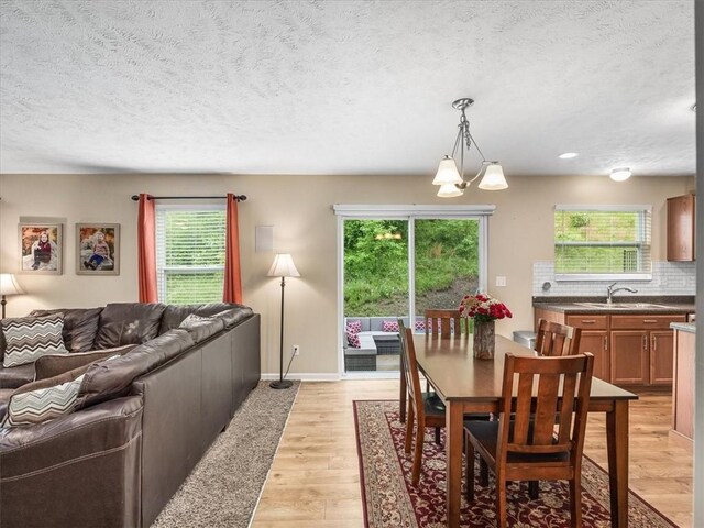 8045 Maureen Dr, Cranberry Twp, PA 16066 - dining room with a textured ceiling, light wood finished floors, and baseboards
