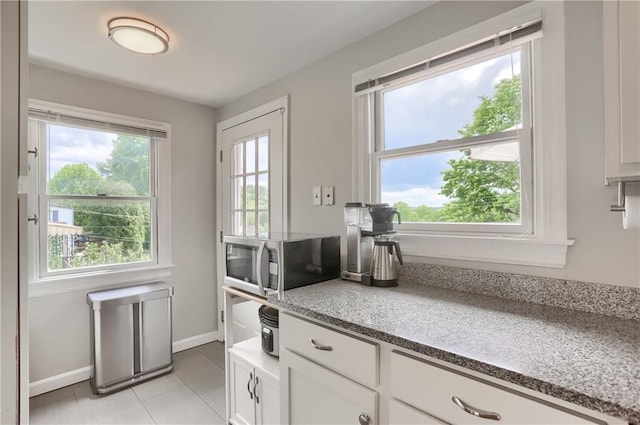 2114 Swallow Hill Rd, Scott Twp Sal, PA 15220 - kitchen featuring stainless steel microwave, white cabinetry, light tile patterned flooring, baseboards, and light stone countertops