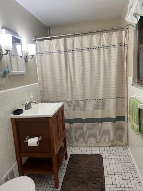 102 Rose Ave, Ross Twp, PA 15229 - bathroom featuring tile walls, toilet, vanity, a wainscoted wall, and a shower with shower curtain