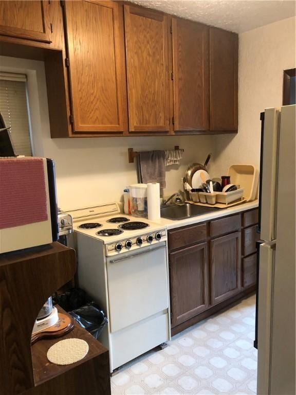 229 Moore Ave, Knoxville, PA 15210 - kitchen featuring white appliances, light flooring, light countertops, and a sink